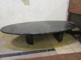 a black table with a black marble top on a tiled floor