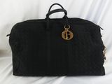 un sac de voyage noir posé sur un drap blanc