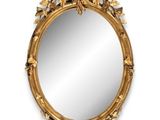 a gold framed mirror with leaves and flowers on it