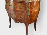 an antique chest of drawers with a marble top on a stand