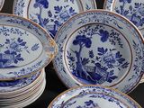many blue and white plates and bowls on a table