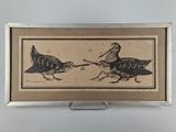 photo encadrée représentant deux oiseaux posés sur une table, sur fond blanc
