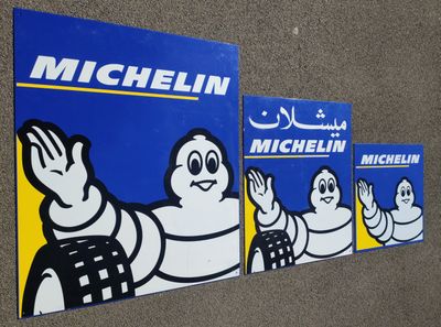 trois autocollants « Michel Michel » accrochés sur la façade d'un immeuble
