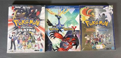 Trois jeux vidéo Pokémon sont exposés sur une table