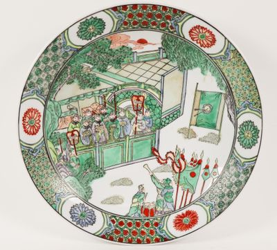 a plate with a picture of people in a garden