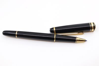 deux stylos à plume noirs et dorés posés sur une surface blanche