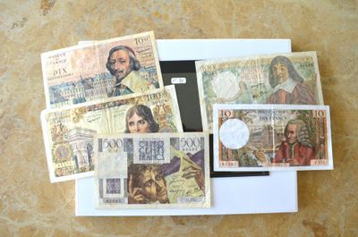 une photo d'une photo montrant une liasse de billets dans une boîte