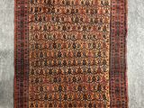 un tapis persan ancien aux motifs rouges et noirs