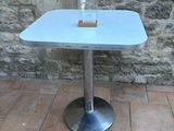 a glass of water sitting on a table in front of a stone wall