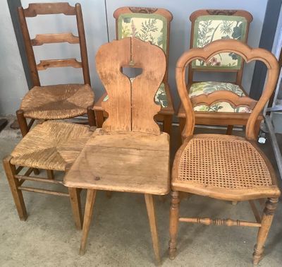quatre chaises en bois placées les unes à côté des autres dans une pièce