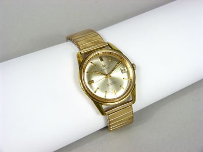 une photo d'une montre en or posée sur une serviette de table