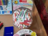 many different pens and pencils on a table