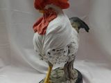 une figurine représentant un coq coiffé d'un chapeau rouge