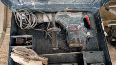 une boîte à outils contenant des outils, posée sur le sol