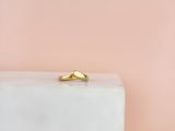 a close up of a gold ring sitting on top of a white block