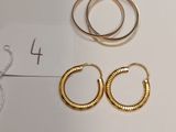 two pairs of gold hoop earrings and a pair of gold hoop earrings