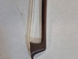 a wooden stick with a long handle on a white surface