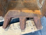 a rusted metal chair sitting on top of a piece of wood