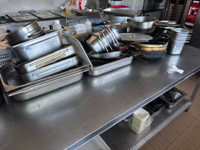 de nombreuses casseroles et poêles sur la table de la cuisine