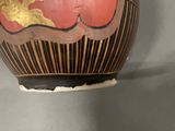 a vase that has a red and gold design on it