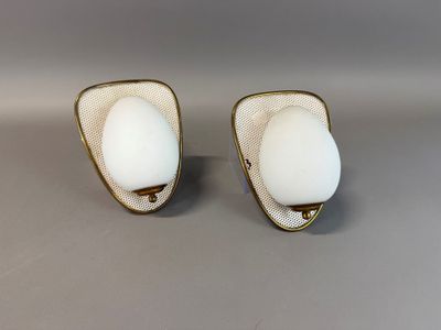 une paire de boucles d'oreilles en verre blanc et plaqué or posées sur un fond gris