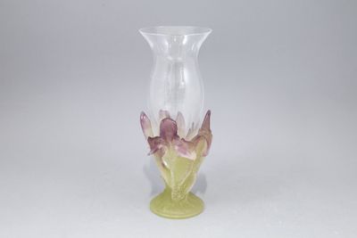vase en verre violet et vert orné de fleurs sur un fond blanc