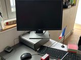 a desk with a computer, keyboard, mouse, and other items on it