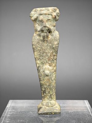 une statue antique représentant un homme barbu sur un socle