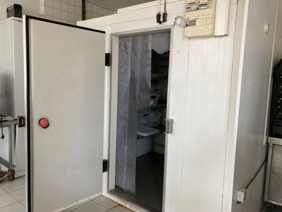 une porte blanche avec un bouton rouge dans une pièce