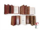 several old books sitting on top of each other on a white surface