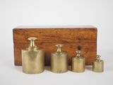 three brass containers and a wooden box on a white surface