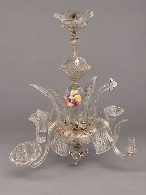 un gros plan d'un lustre en verre orné de fleurs