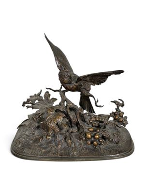 sculpture en bronze représentant un oiseau posé sur un rocher, entouré de fleurs et d'oiseaux
