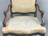 an old chair with a beige upholstered seat and a wooden frame