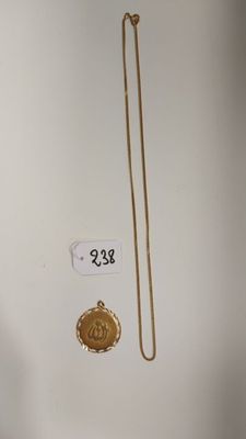 un collier en or et une chaîne en or ornée d'un médaillon