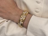 a woman that is wearing a gold and diamond bracelet