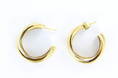 une paire de boucles d'oreilles en or sur fond blanc