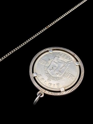 l'image d'une pièce d'argent attachée à une chaîne sur fond noir