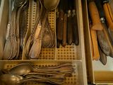 un tiroir rempli d'argenterie et de cuillères dans une cuisine