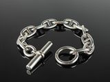 a close up of a chain bracelet with a clasp on a black surface