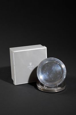 silver plate and box on a black surface with a black background