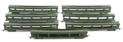 six green train cars sitting next to each other on a white surface