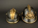 pair of helmets with gold decoration on them on a black background