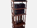 a tall wooden shelf with many electronics on it