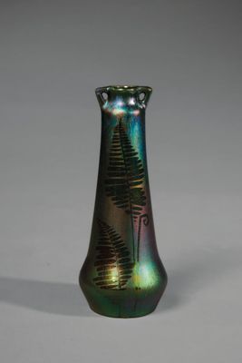 un vase vert orné d'un motif de fougère