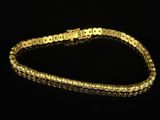 a close up of a gold bracelet on a black background
