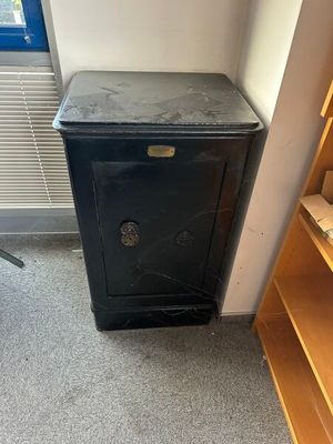 a small black cabinet in the corner of a room