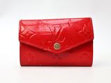 a red louis vuitti wallet with gold hardware