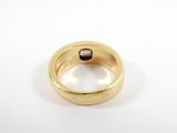 an image of a gold ring with a black stone in it