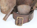 a brown belt with a metal buckle on a table